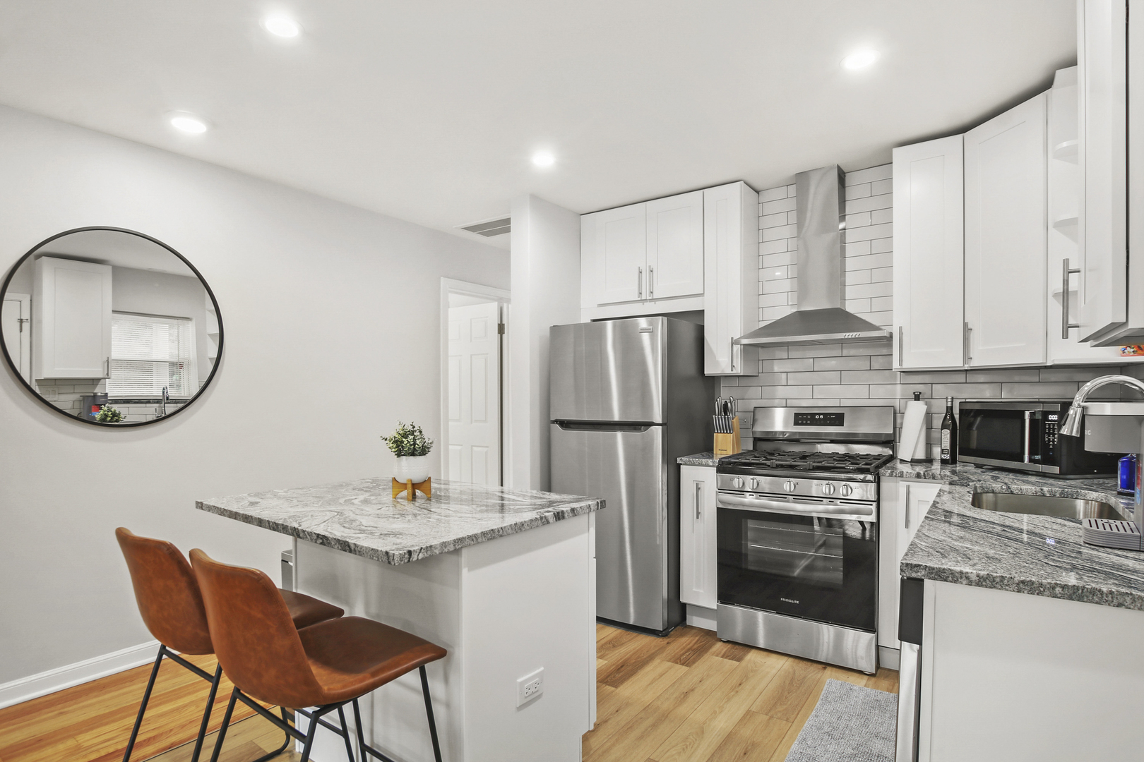 236 Callan Avenue, Unit 3 Evanston, IL 60202 - Photo 4 of 15 a kitchen with stainless steel appliances granite countertop a stove a refrigerator a kitchen island a dining table and chairs