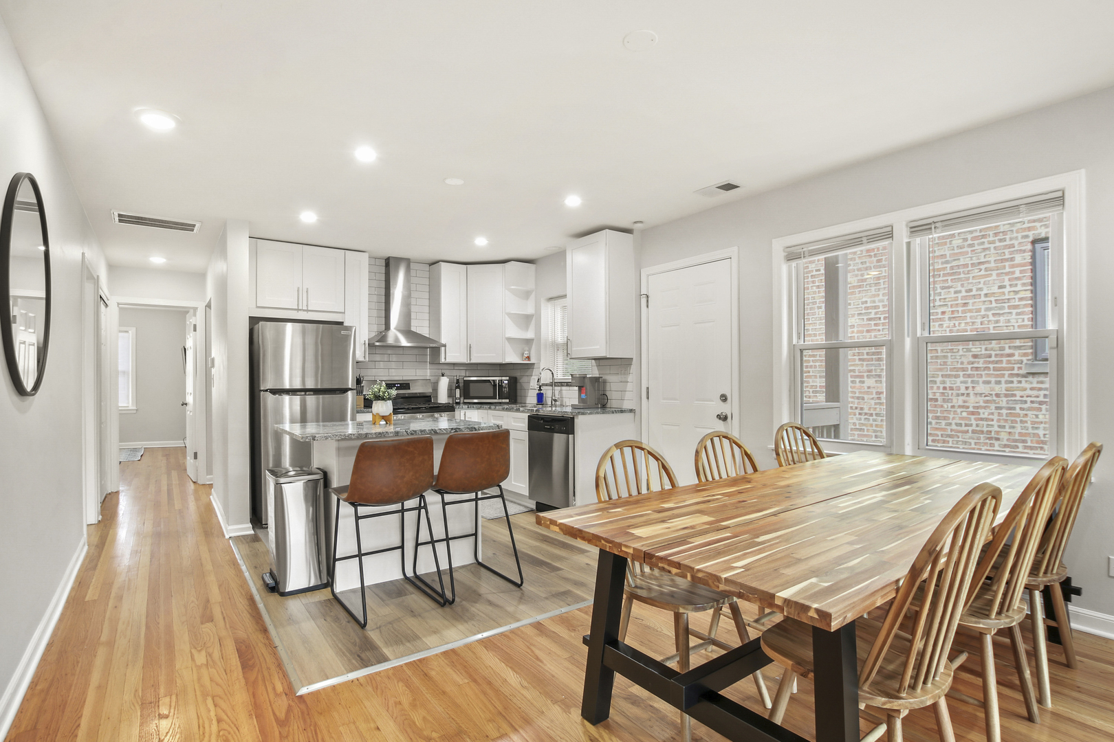 236 Callan Avenue, Unit 3 Evanston, IL 60202 - Photo 6 of 15 a kitchen with stainless steel appliances granite countertop a stove a refrigerator a kitchen island and chairs with wooden floor