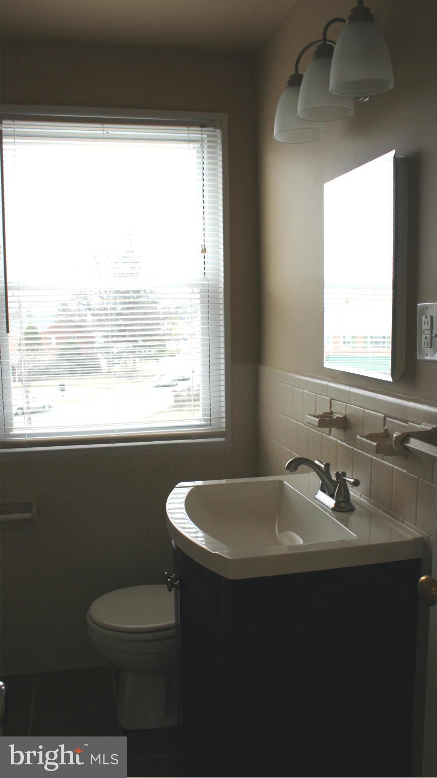 5406 Whitlock Road Baltimore, MD 21229 - Photo 14 of 25 a bathroom with a sink a toilet and a window