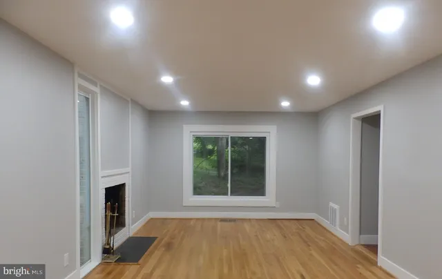 a view of an empty room with a fireplace and a window