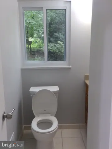 a white toilet sitting in a bathroom next to a window