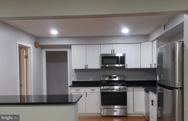 a kitchen with stainless steel appliances a refrigerator a stove a microwave and cabinets