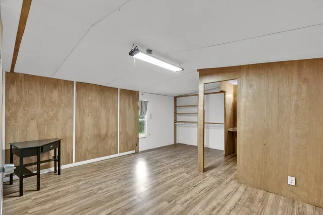 a view of a kitchen with a closet and wooden floor