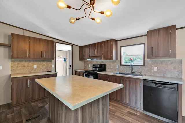a kitchen with a stove a sink a microwave and wooden cabinets