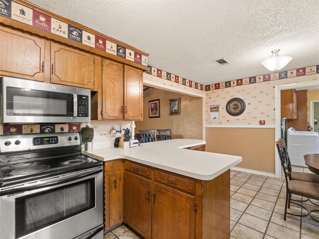 571 County Road Daingerfield, TX 75638 - Photo 24 of 34 a kitchen with a stove a microwave and a refrigerator