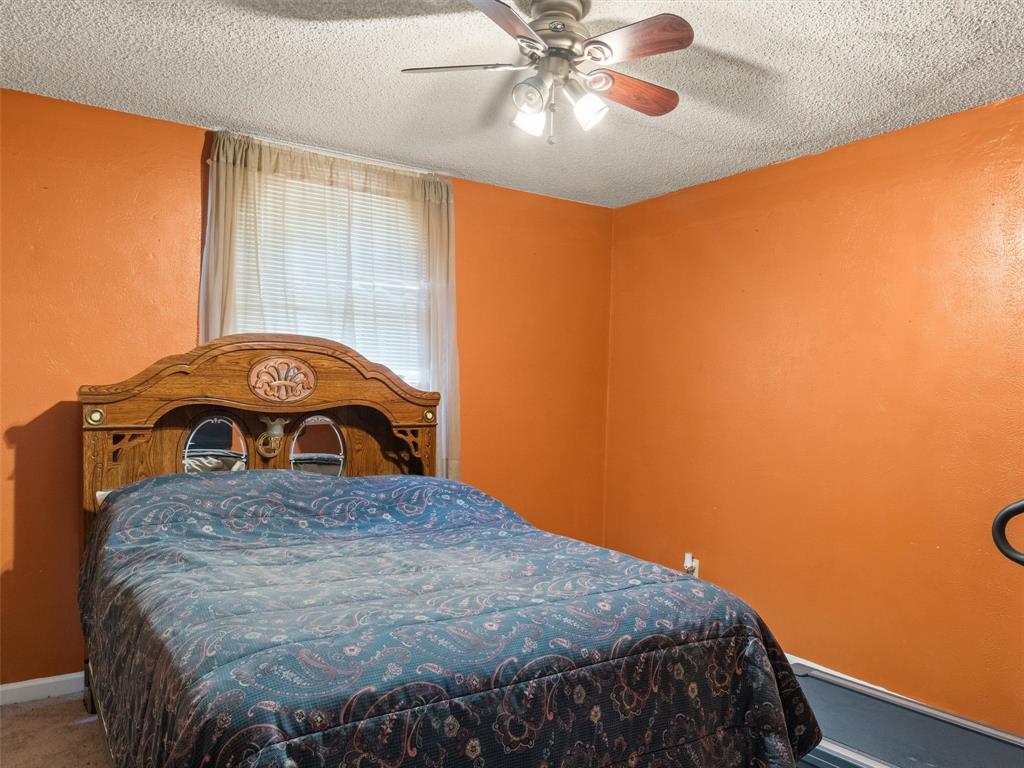 571 County Road Daingerfield, TX 75638 - Photo 28 of 34 a bedroom with a bed and a chandelier
