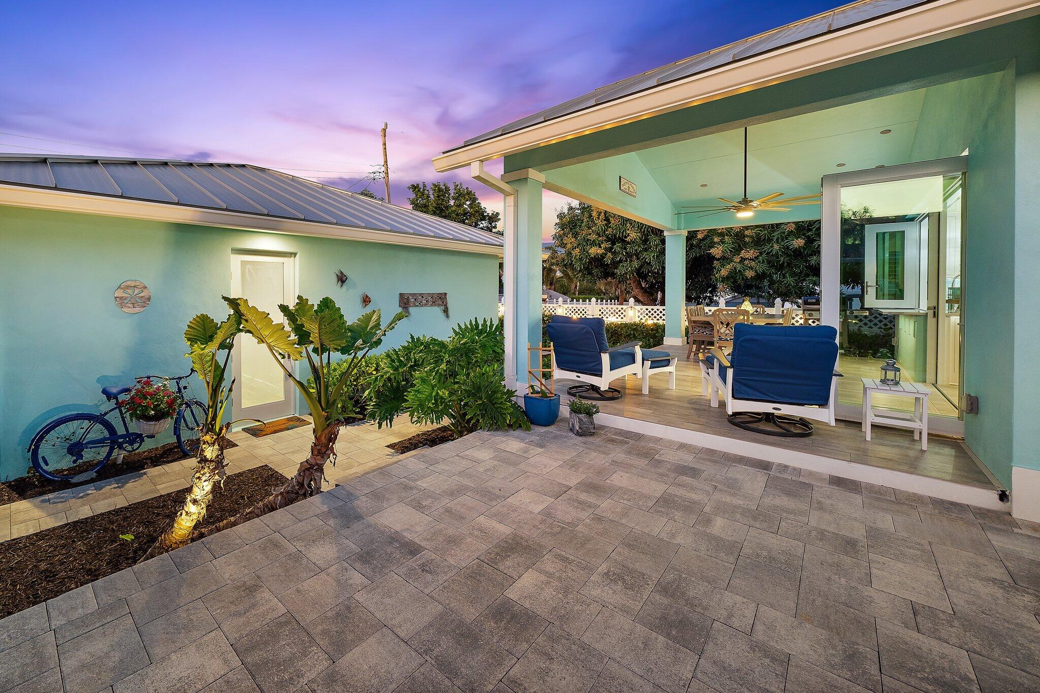 3443 Inlet Court Jupiter, FL 33469 - Photo 5 of 59 a view of a patio with table and chairs under an umbrella