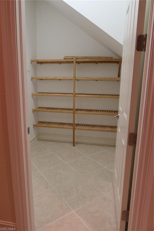 7168 Lemuria Circle, Unit 1701 Naples, FL 34109 - Photo 15 of 39 Storage area featuring light-toned tile flooring and multiple slatted wood shelves