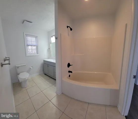a spacious bathroom with a bathtub and toilet