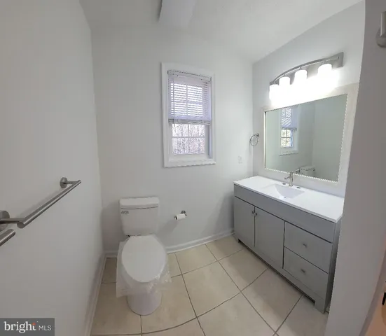 a spacious bathroom with a toilet sink and mirror
