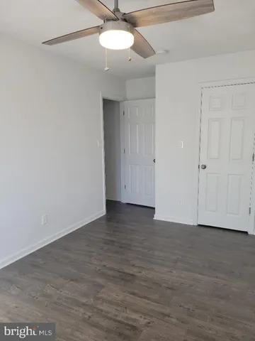 a view of an empty room with a chandelier fan