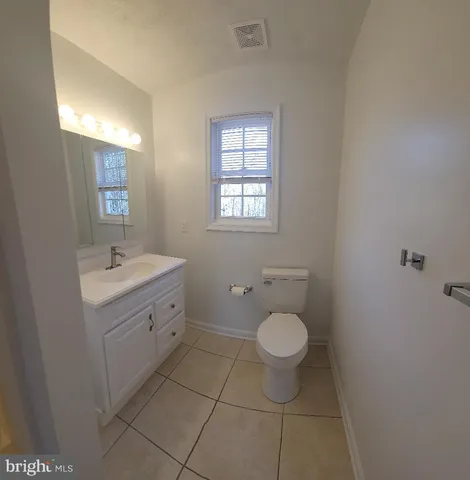 a spacious bathroom with a toilet sink and mirror