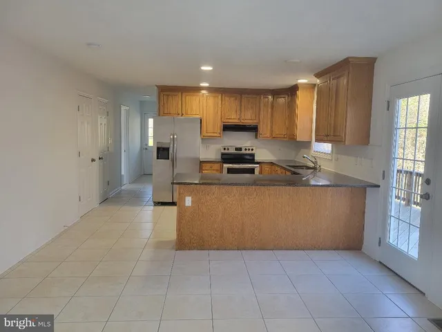 a kitchen with stainless steel appliances granite countertop a stove a sink and a refrigerator