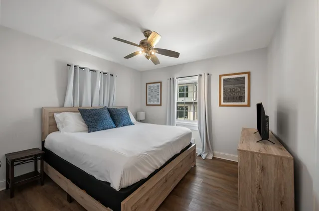 a spacious bedroom with a bed and a flat screen tv