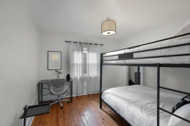 a bedroom with bed and wooden floor