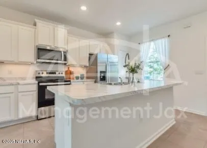 a kitchen with stainless steel appliances granite countertop a sink a stove and a refrigerator