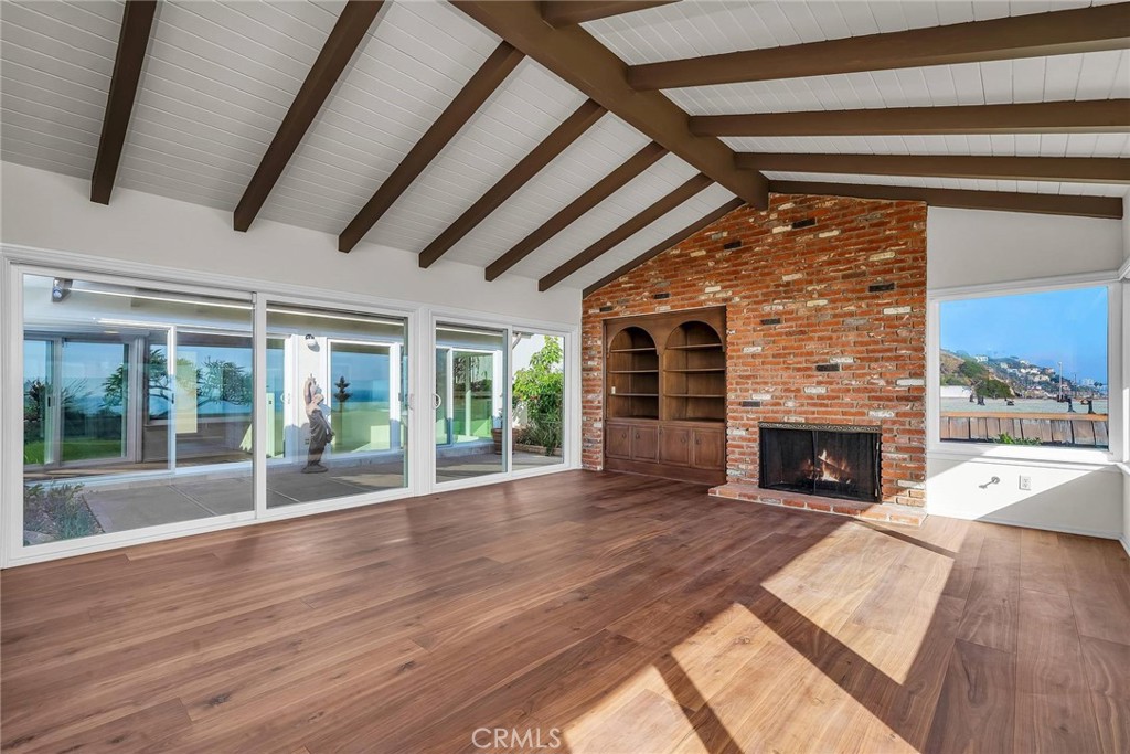 18034 Coastline Drive Malibu, CA 90265 - Photo 5 of 24 a view of a livingroom with wooden floor a fireplace and window