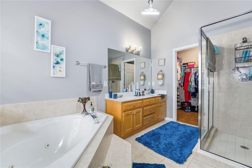 170 Sable Trace Trail Acworth, GA 30102 - Photo 23 of 48 a bathroom with a tub a sink and a large mirror
