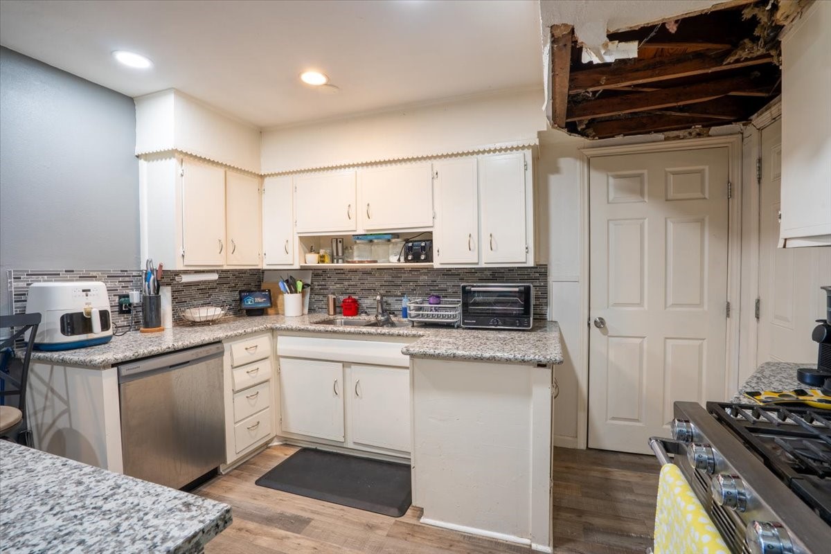 10601 Buffum Street Houston, TX 77051 - Photo 11 of 50 a kitchen with stainless steel appliances granite countertop a stove a sink and a refrigerator