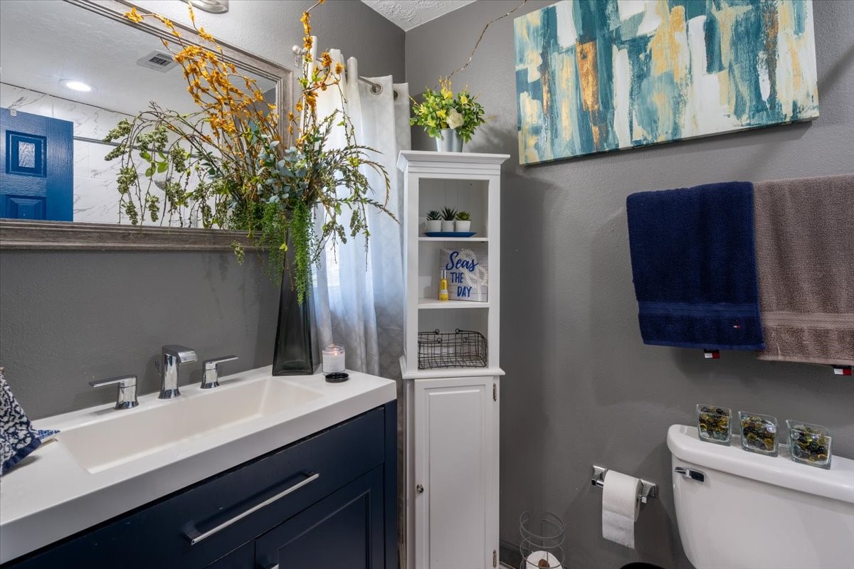 10601 Buffum Street Houston, TX 77051 - Photo 23 of 50 a bathroom with a sink a toilet and mirror