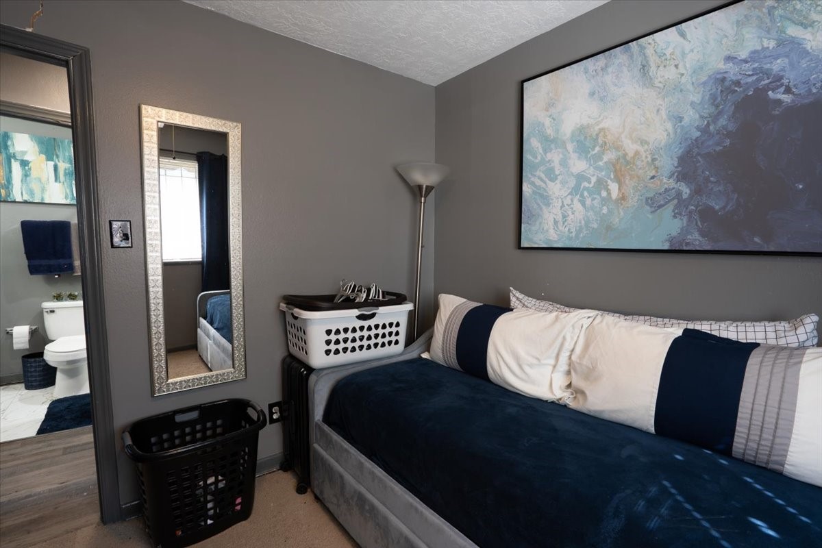 10601 Buffum Street Houston, TX 77051 - Photo 28 of 50 a bedroom with a bed and wooden floor