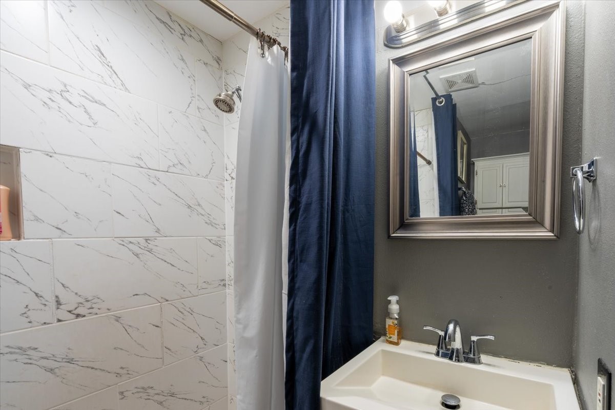 10601 Buffum Street Houston, TX 77051 - Photo 41 of 50 a bathroom with a sink and mirror with shower