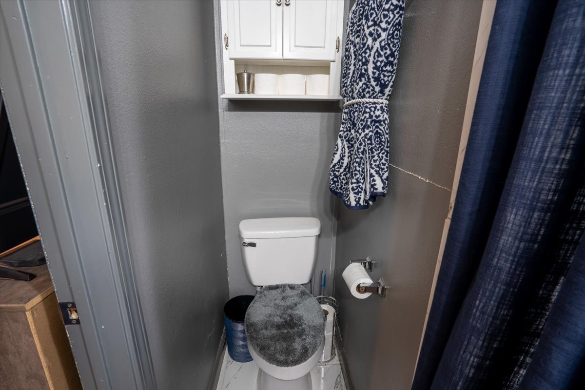 10601 Buffum Street Houston, TX 77051 - Photo 42 of 50 a bathroom with a toilet and a shower curtain