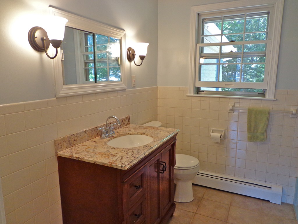16 Juniper Lane Rutland, MA 01543 - Photo 11 of 22 a bathroom with a granite countertop sink a toilet and a window