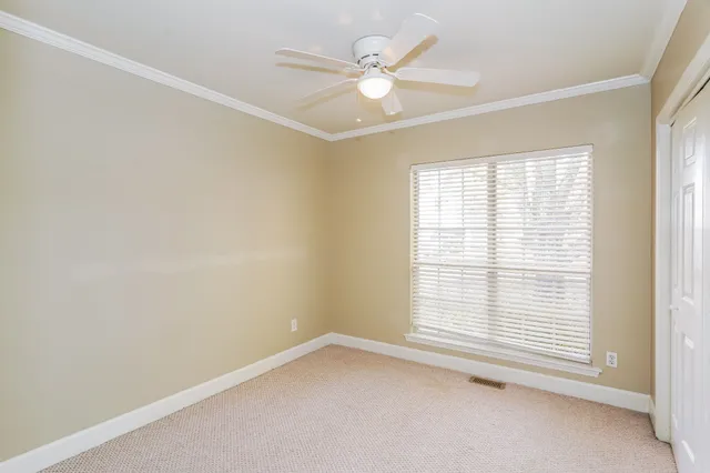an empty room with a window and a ceiling fan
