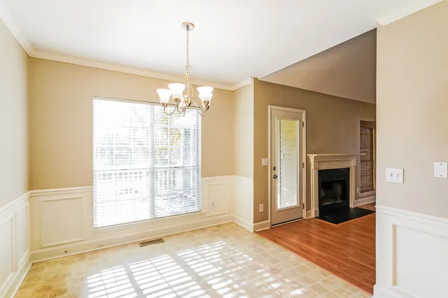 a view of an empty room with a window and chandelier