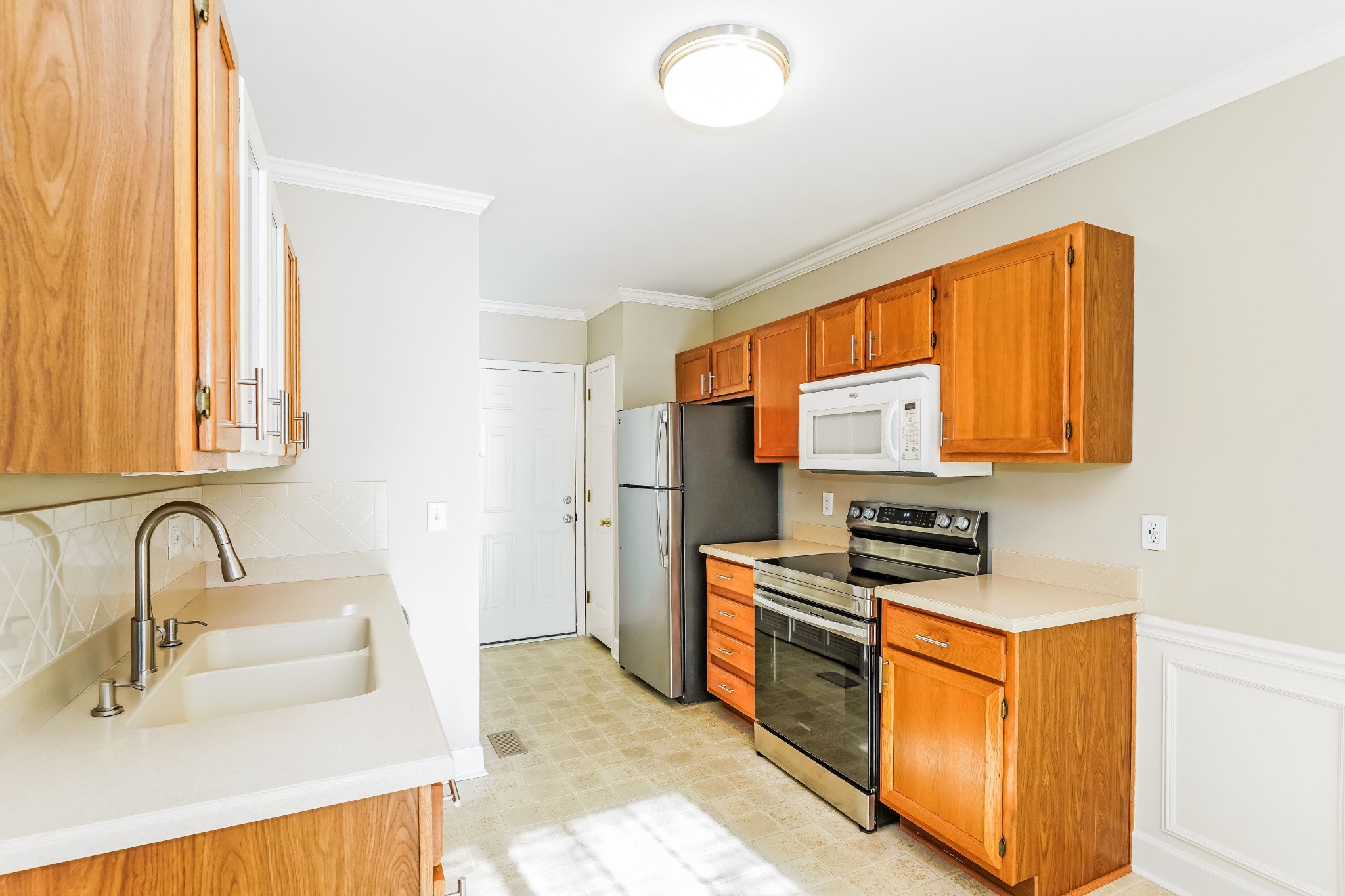306 Crooked Oak Court Franklin, TN 37067 - Photo 9 of 27 a kitchen with stainless steel appliances a sink stove and cabinets