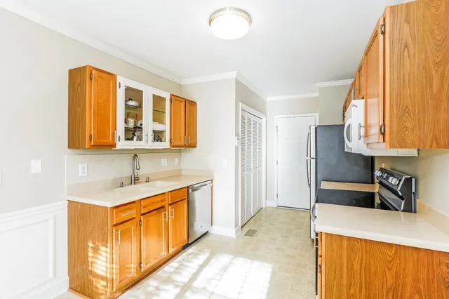 a kitchen with stainless steel appliances granite countertop a sink a stove and a refrigerator
