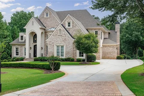 a front view of a house with a garden and trees
