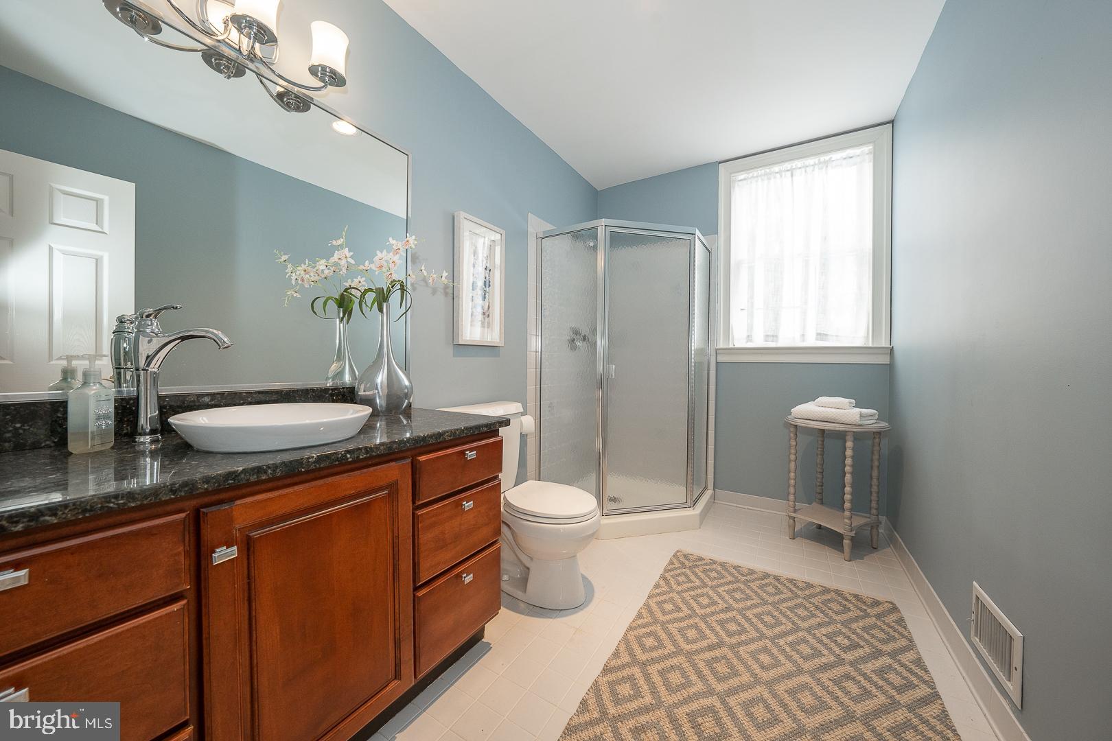 400 Orchard Way Wayne, PA 19087 - Photo 25 of 60 a bathroom with a granite countertop toilet a sink a mirror a window and vanity