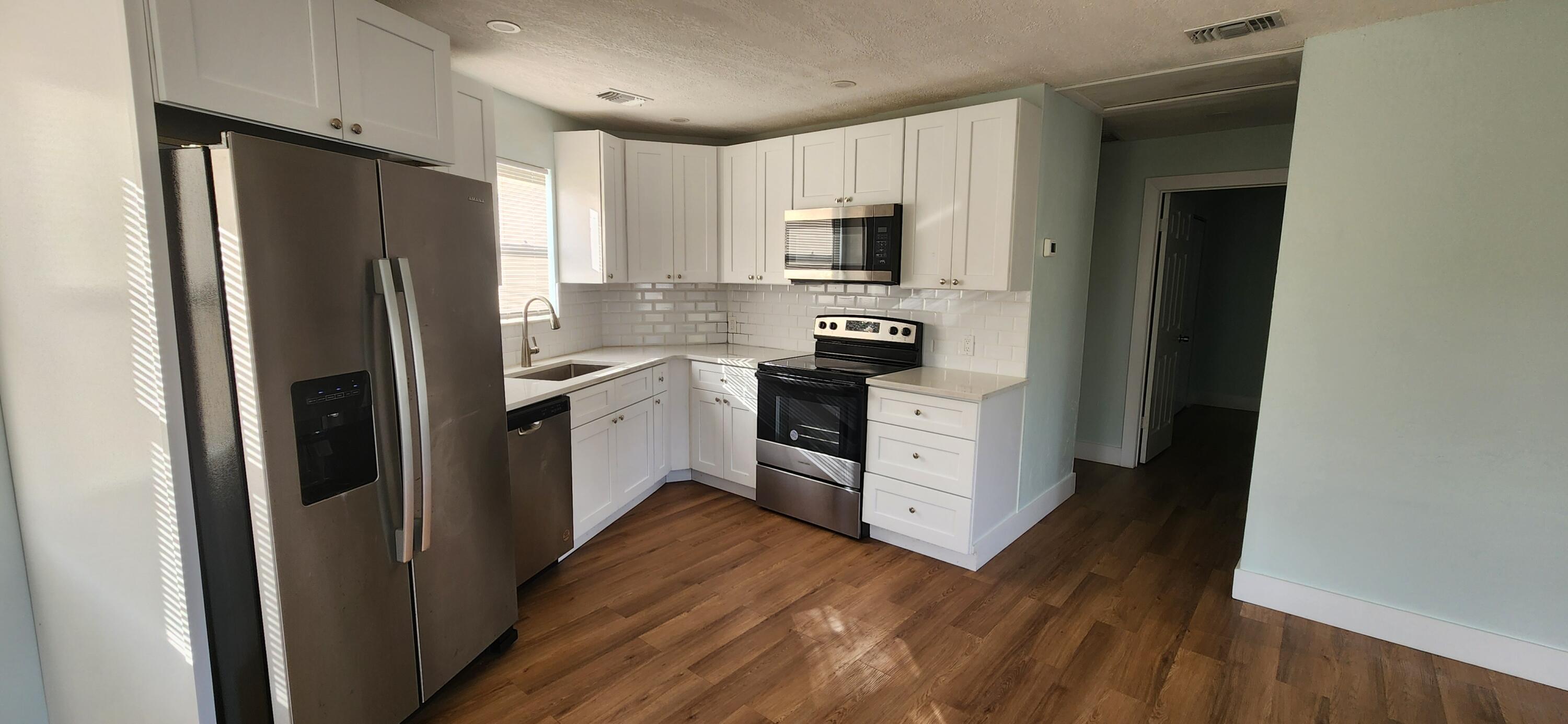 a kitchen with white cabinets and stainless steel appliances