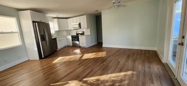 a kitchen with a refrigerator and wooden floor