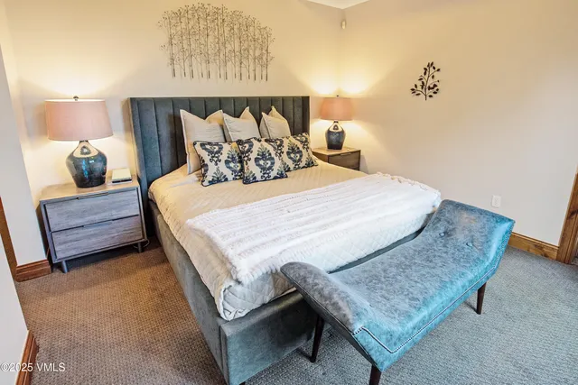 a bedroom with a bed and a lamp with the dresser