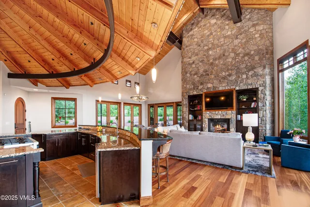 a living room with furniture a large window and wooden floor