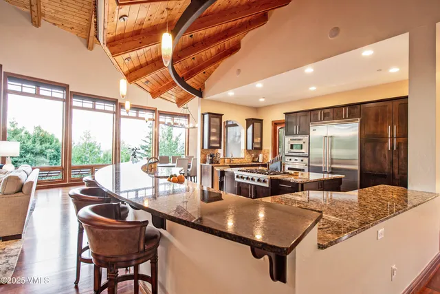 a kitchen with a table chairs stove and granite counter top