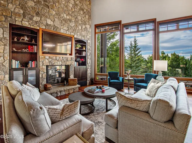 a living room with furniture a floor to ceiling window and a flat screen tv