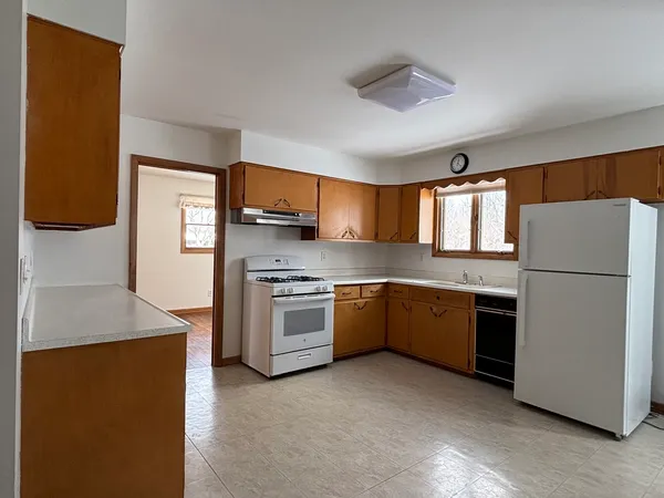 a kitchen with stainless steel appliances granite countertop a refrigerator a oven a sink a stove and white cabinets