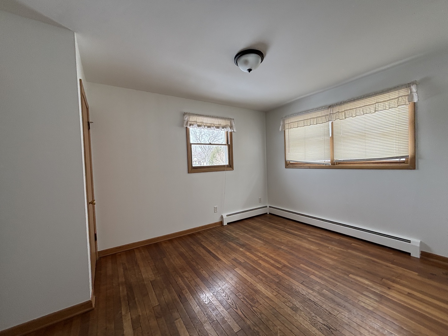 2208 Stieg Road Woodstock, IL 60098 - Photo 8 of 15 an empty room with wooden floor and windows