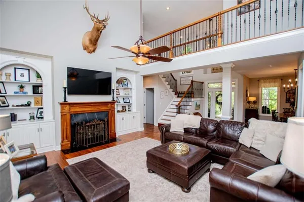 a kitchen with stainless steel appliances granite countertop a stove top oven a sink a dining table and chairs with wooden floor