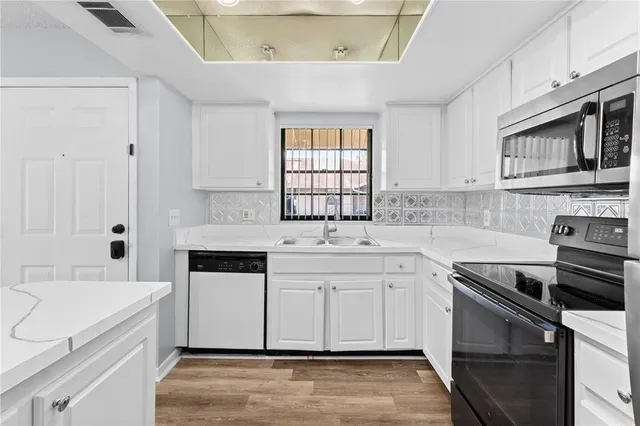 a kitchen with a sink stove top oven and cabinets