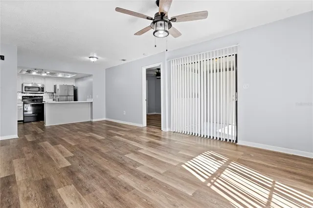 a view of a kitchen with wooden floor and a ceiling fan