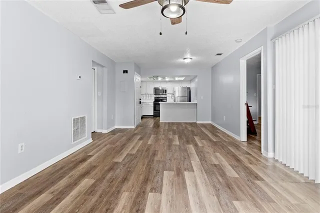 a view of empty room with wooden floor