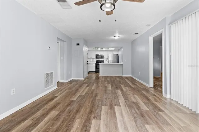 a view of empty room with wooden floor