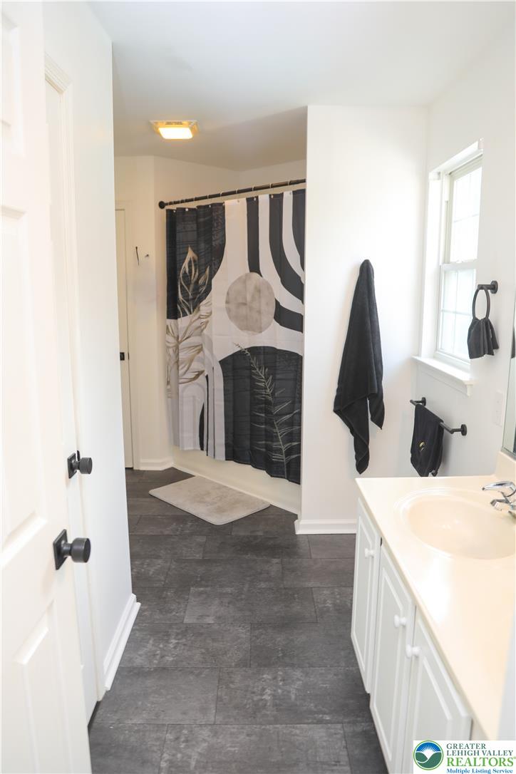 1412 Stanford Road Bethlehem, PA 18018 - Photo 42 of 58 Functional full bathroom featuring a crisp white vanity and practical dark tile flooring.