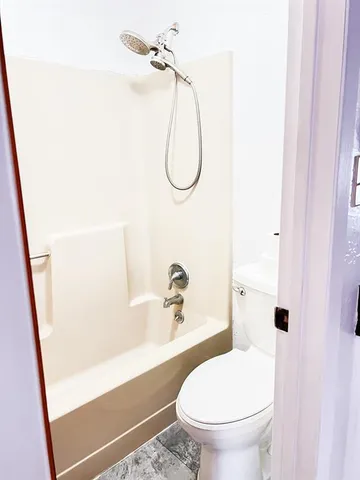 a bathroom with a toilet and a shower