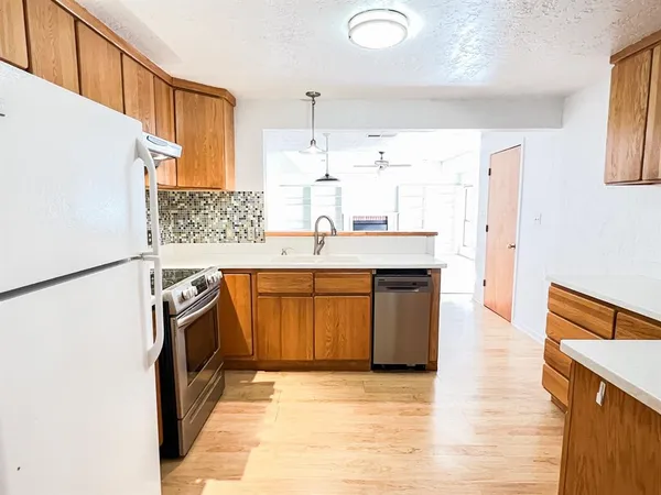 a kitchen with stainless steel appliances granite countertop a sink stove and refrigerator